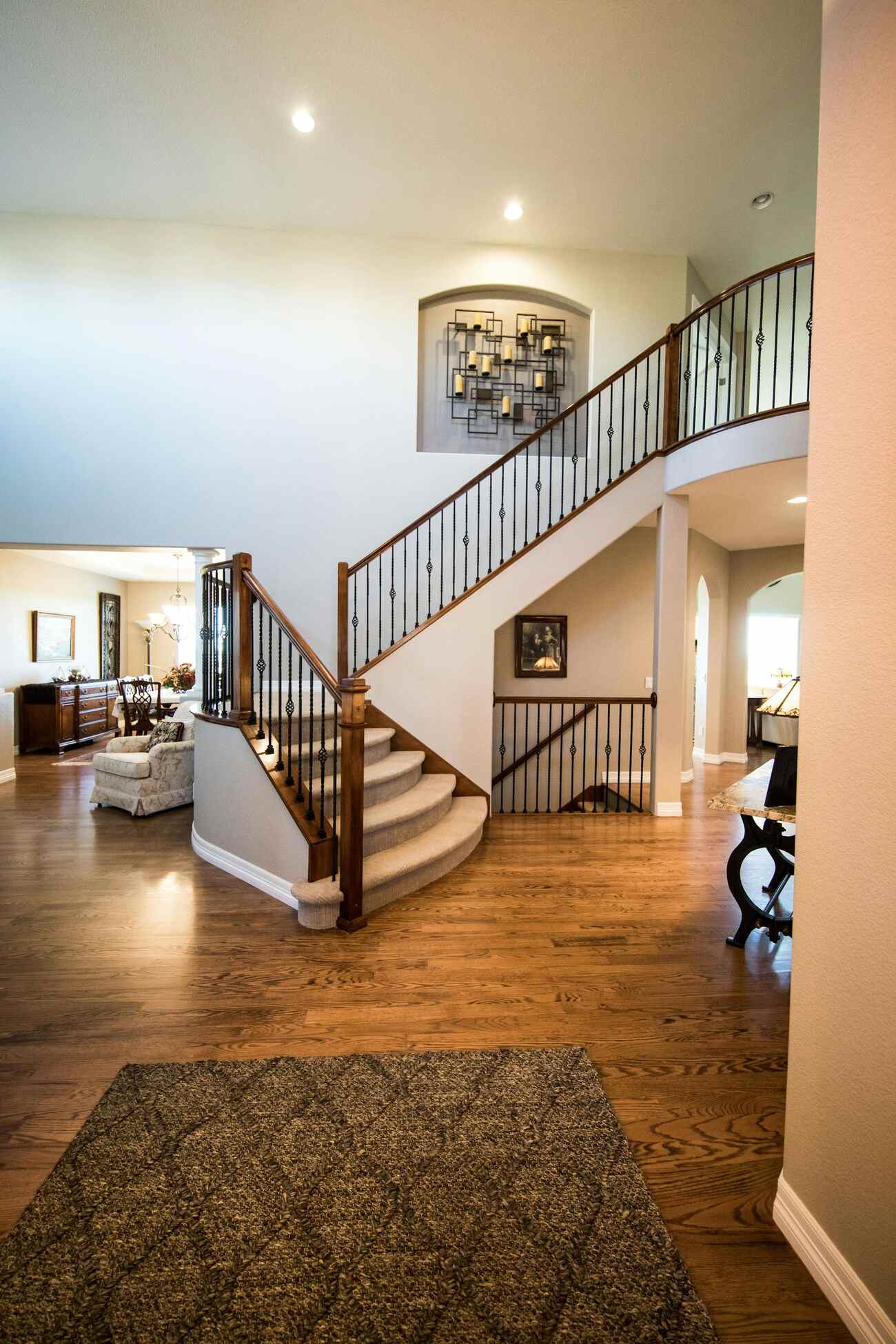 A spacious foyer featuring a grand staircase and polished hardwood floors