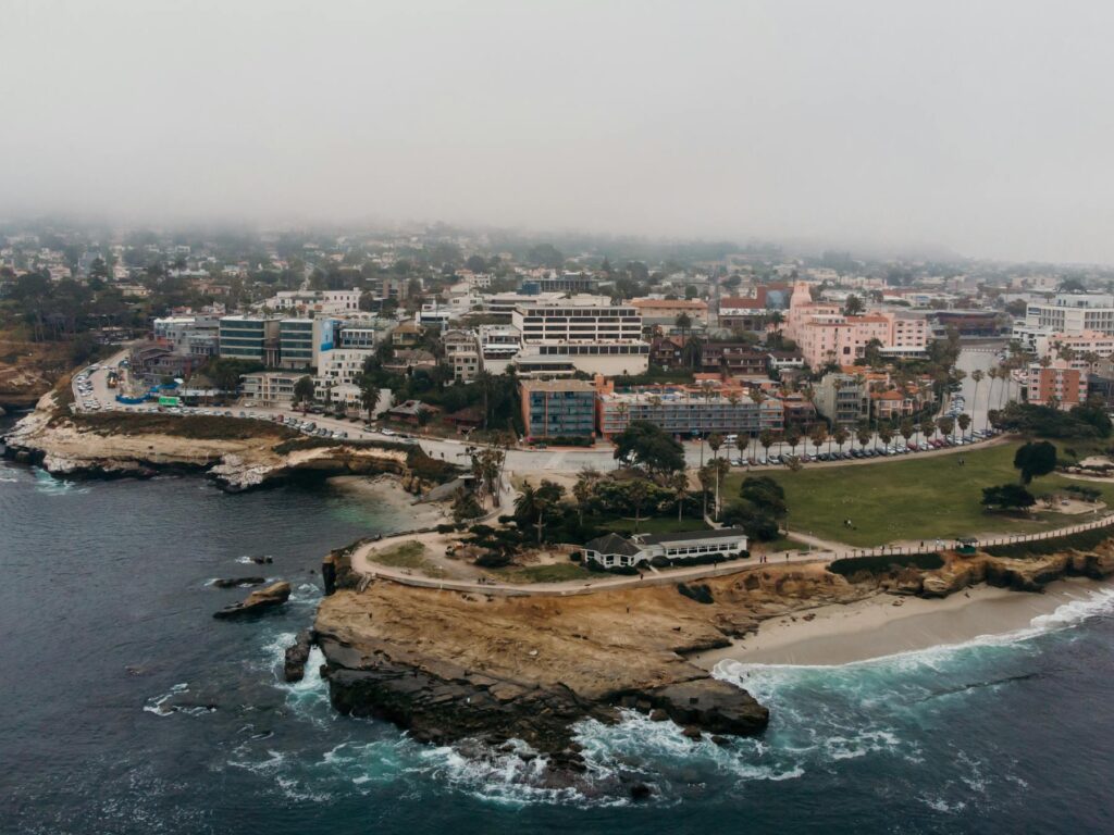 Aerial view of coastal town with rocky cliffs and waterfront buildings
