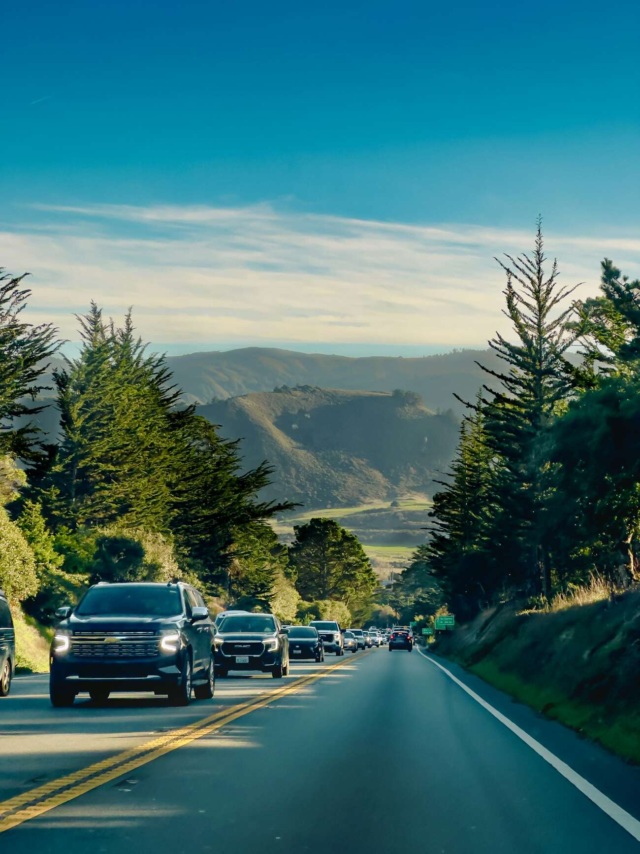 Traffic on Carmel Valley Road through rolling hills